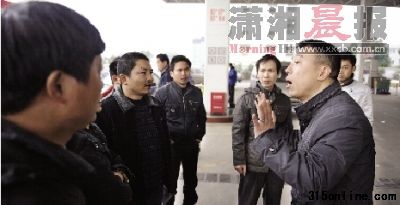 昨日,萬家麗北路一加油站內(nèi), 加油站負(fù)責(zé)人(右)在和的哥們進(jìn)行溝通。 圖/記者秦樓