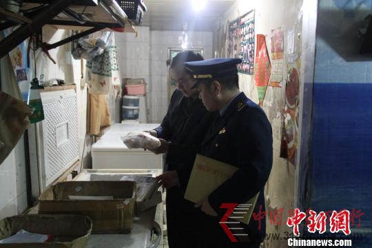 執法人員在水產店內檢查。 韓璐 攝 執法人員在水產店內檢查。 韓璐 攝