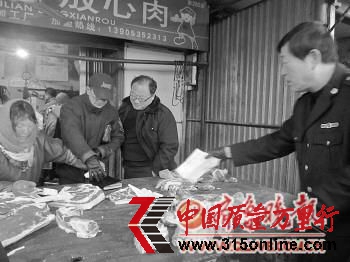 執(zhí)法人員在市場上檢查“兩證”。本報記者 孫芳芳 攝