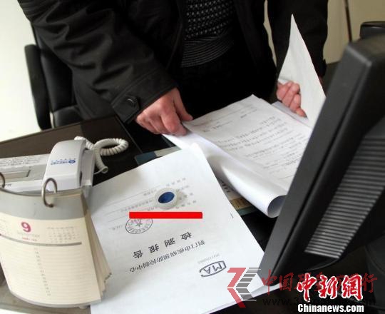 湖北省荊門市衛生監督局工作人員向記者介紹肯德基湖北荊門店食品吃出異物調查情況,圖中紅線處為肯德基漢堡里面吃出的塑料蓋。 吳奇勇 攝 湖北省荊門市衛生監督局工作人員向記者介紹肯德基湖北荊門店食品吃出異物調查情況,圖中紅線處為肯德基漢堡里面吃出的塑料蓋。 吳奇勇 攝
