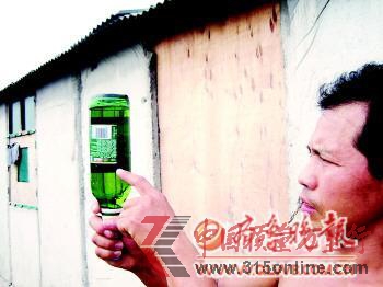 孫先生拿著一瓶含有絮狀物的啤酒。 孫先生拿著一瓶含有絮狀物的啤酒。