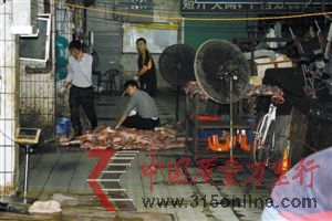 幾名男子正在切割成堆的問題豬肉。 幾名男子正在切割成堆的問題豬肉。